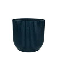 Vibes pot in soft blue hue with unique ribbed texture, perfect for displaying vibrant foliage.